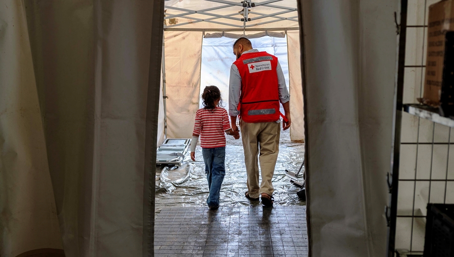 Ei lita jente leies av helsepersonell gjennom et feltsykehus