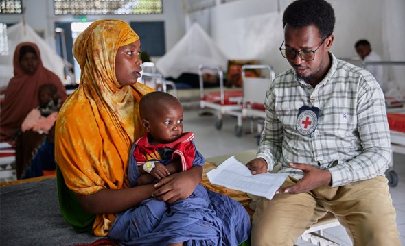 Liten jente med gipset ben i en seng