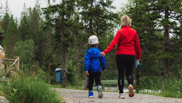 Dame fra Røde Kors på tur med barn i skogen