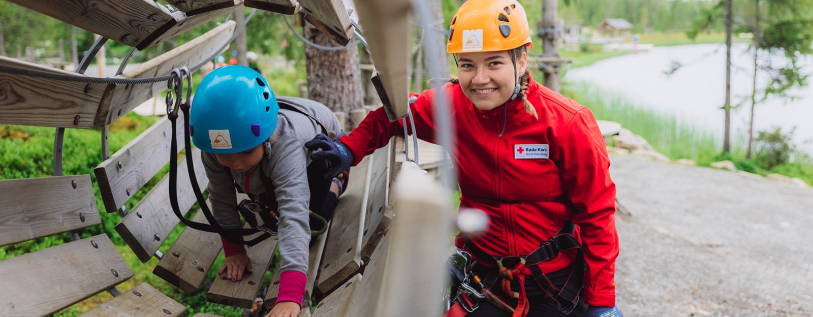 Barn som koser seg på ferie for alle med klatring i klaterepark.