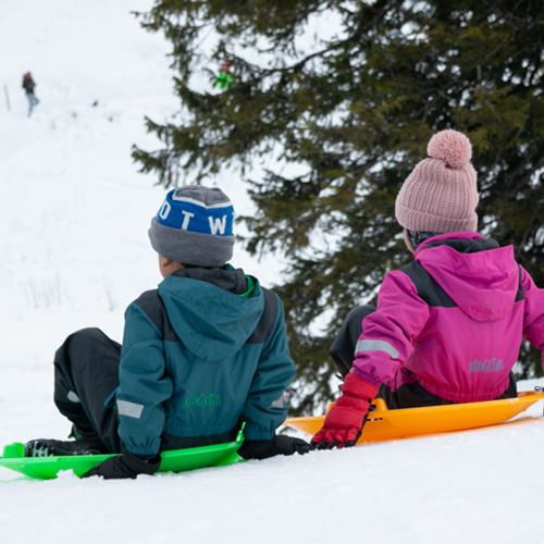 Barn som koser seg med ferie for alle og aker ute i snøen.