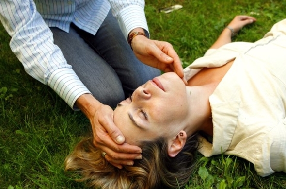 Person utfører førstehjelp på en bevisstløs kvinne