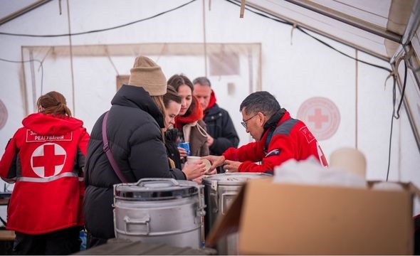 Utdeling av varm mat og drikke på en varmestasjon i Kyiv, Ukraina