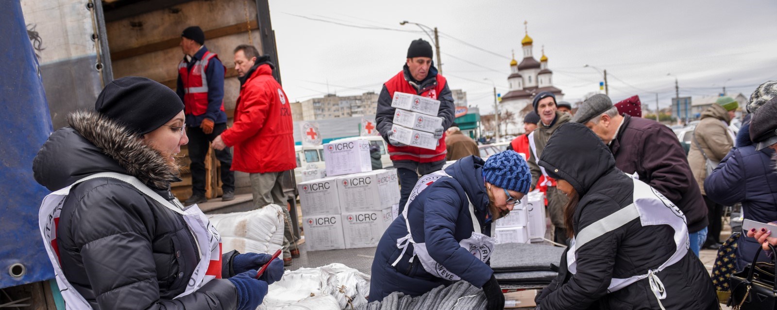 Mange personer fra Røde Kors laster av esker med nødhjelp fra en lastebil.