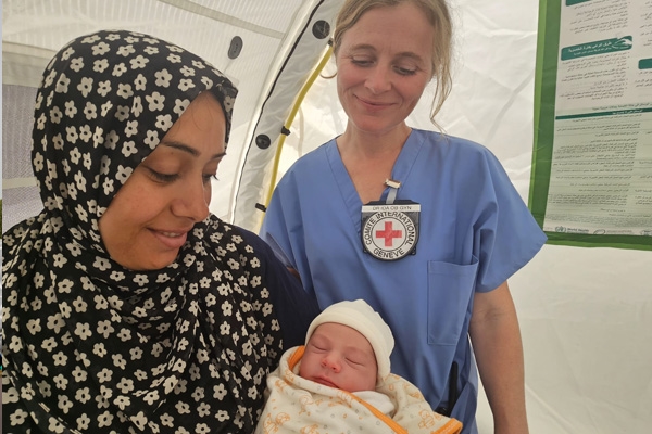 Gynekologen Ida , står sammen med en mamma som holder en nyfødt baby i armene