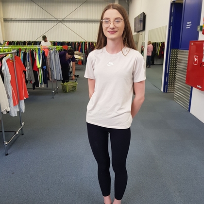 dame foran hengere med tøy