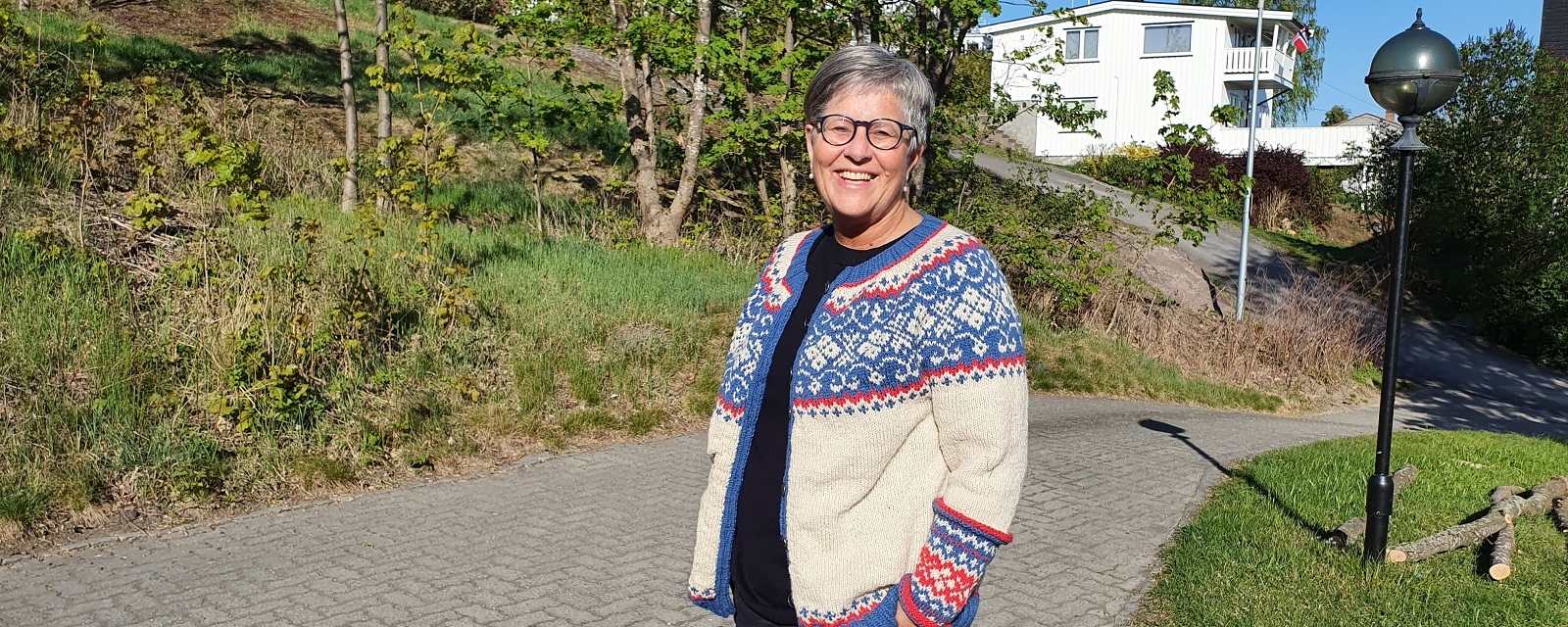 Kvinne antrukket strikkegenser som smiler