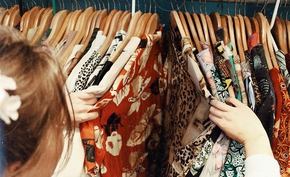 Kvinne ser igjennom klær i butikk