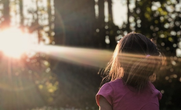 Solskinn som treffer barn i skogen