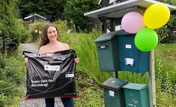 Kvinne holder Røde Kors-pose fylt med tøy