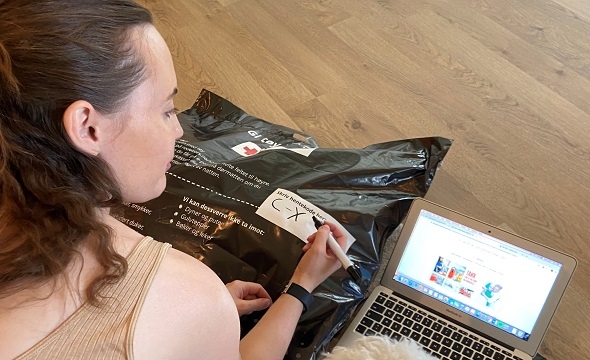 Kvinne holder en Røde Kors-pose med tøy