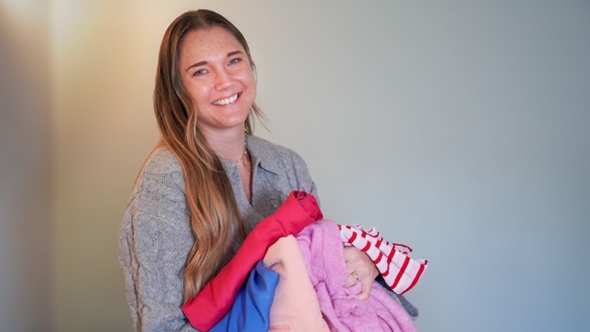 kvinne holder klær i hendene