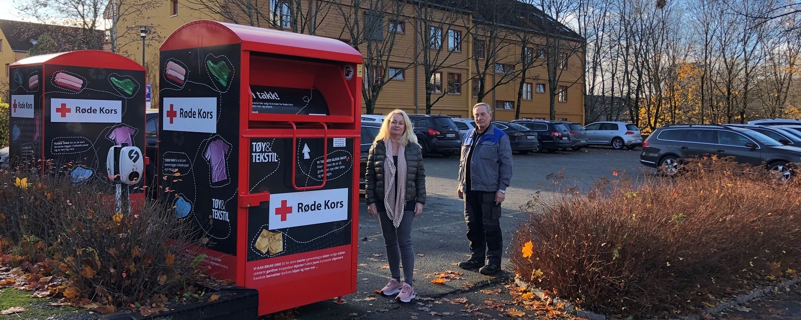 Styreleder og vaktmester ved siden av innsamlingsboks fra Røde Kors