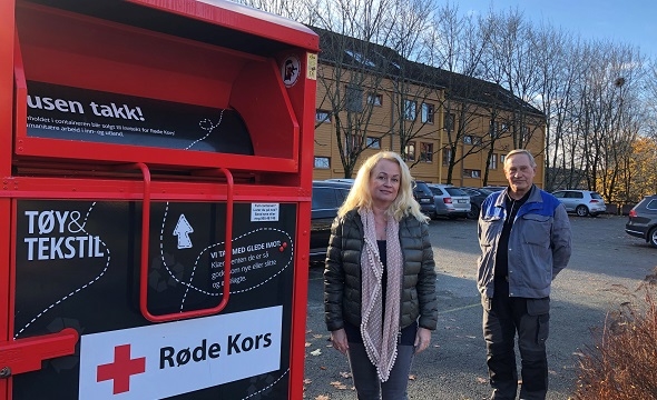 Styreleder og vaktmester ved siden av innsamlingsboks fra Røde Kors