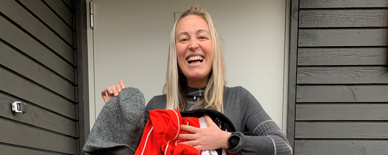 Treningsprofil Stine Hartmann holder opp klær hun donerer til Røde Kors