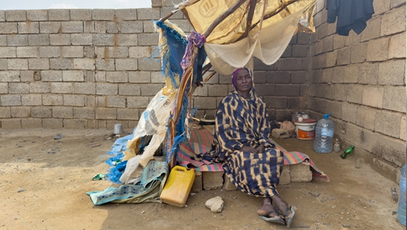 Dame sitter ute i hjemmelaget telt i Sudan
