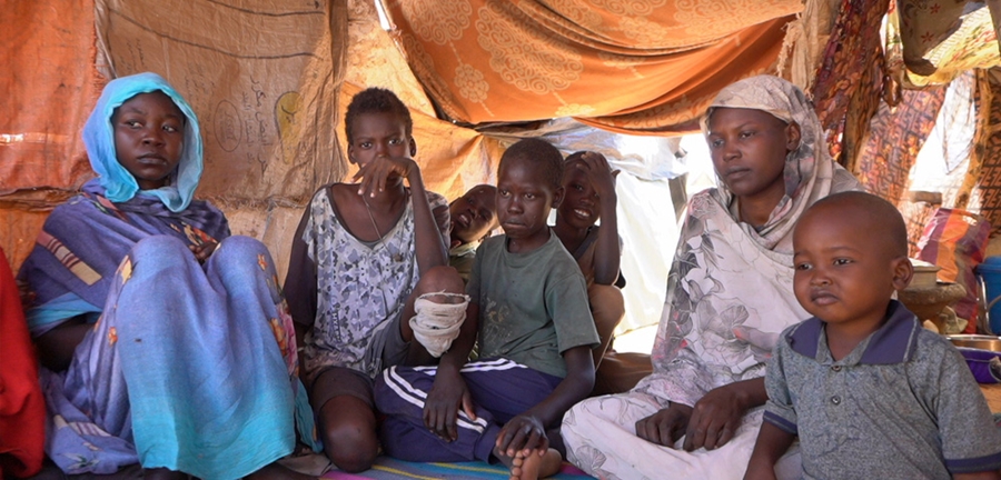 En familie i Sudan sitter inne i et telt
