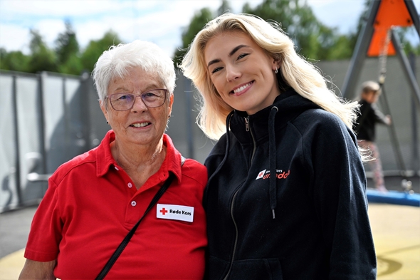 To smilende kvinner utendørs.