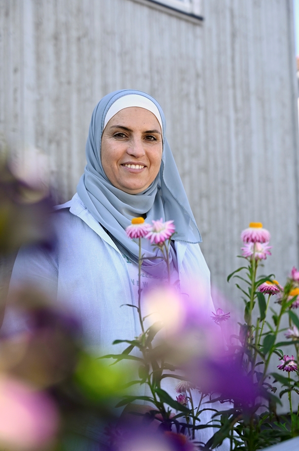 Smilende kvinne omringet av blomster