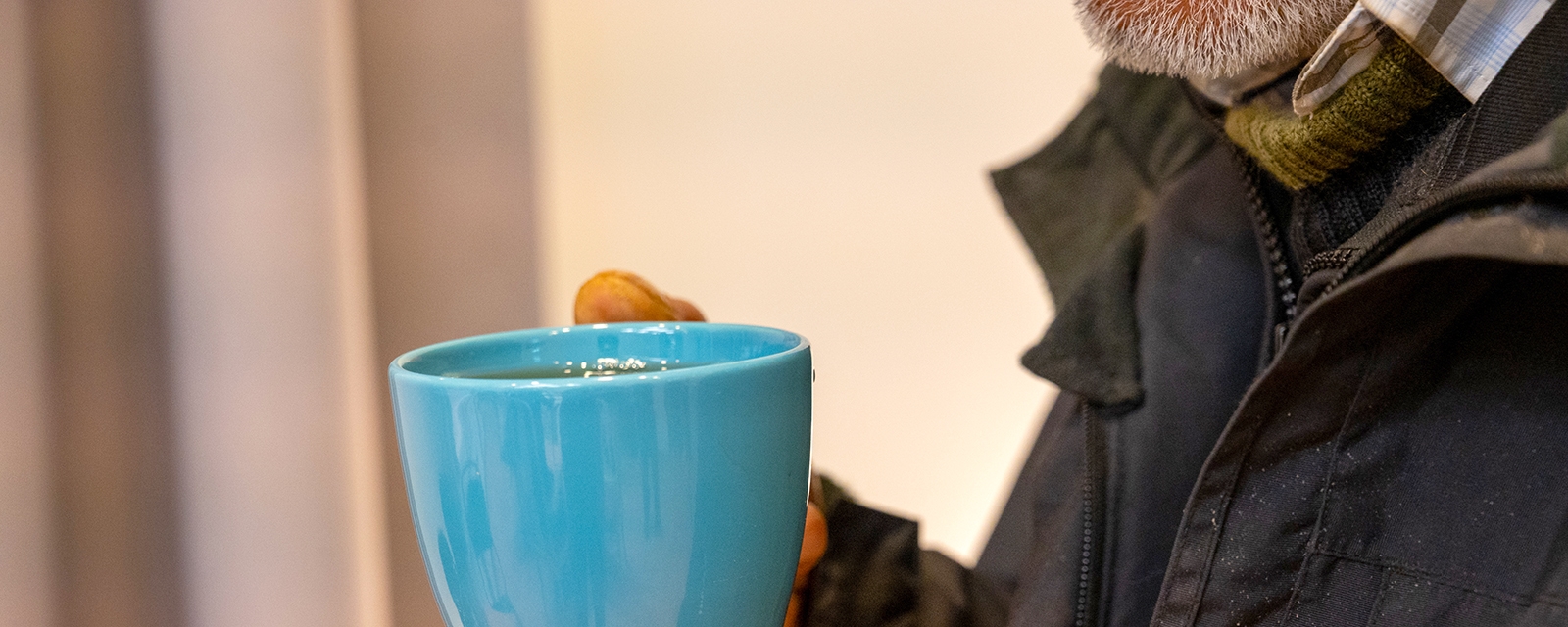 en hånd som holder en blå kopp