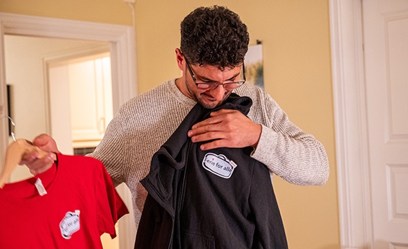 Ahmed viser frem en T-skjorte fra Ferie for alle.