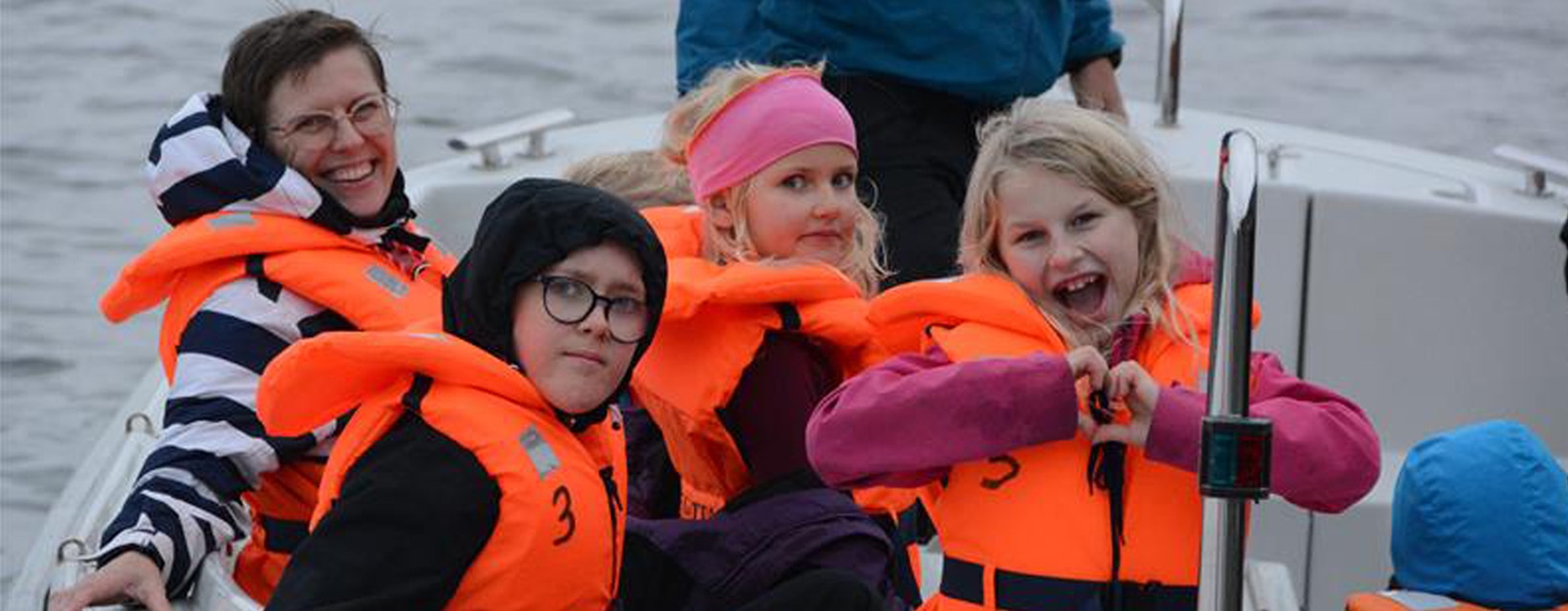 Barn i redningsvest på båt