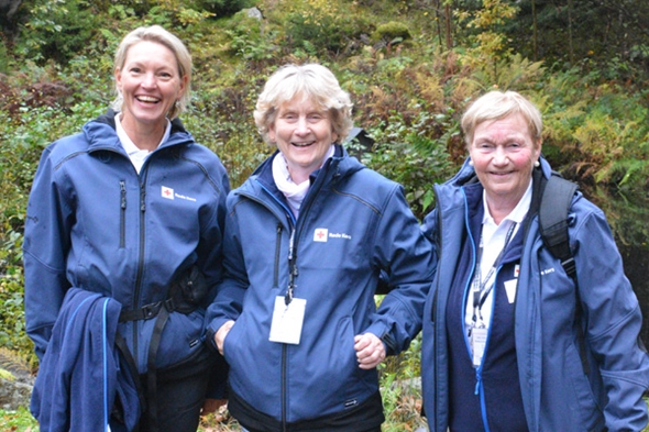 tre voksne damer smiler til kamera ute