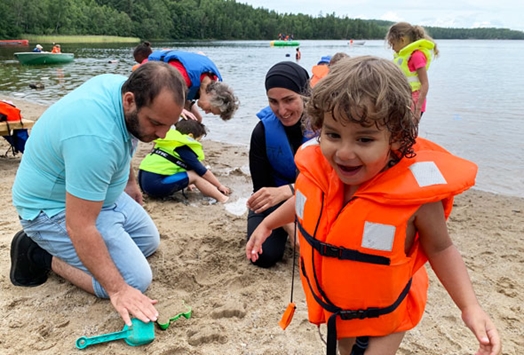 Familie leker i vannkanten