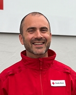 Mann med rød fleece og røde kors logo