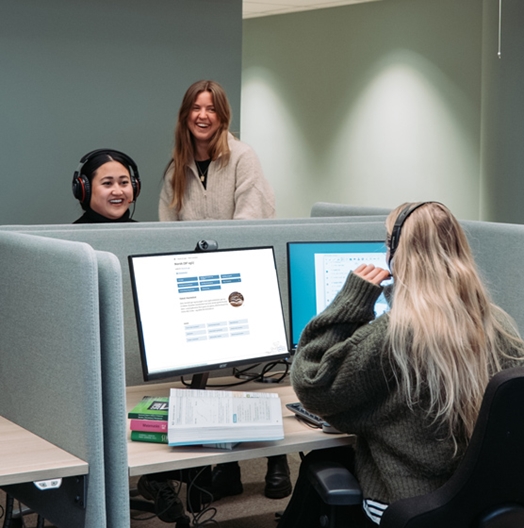 tre kvinner smiler kontorlandskap