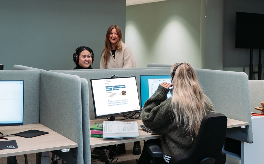 Personer sitter foran data skjermer på jobb for Røde Kors