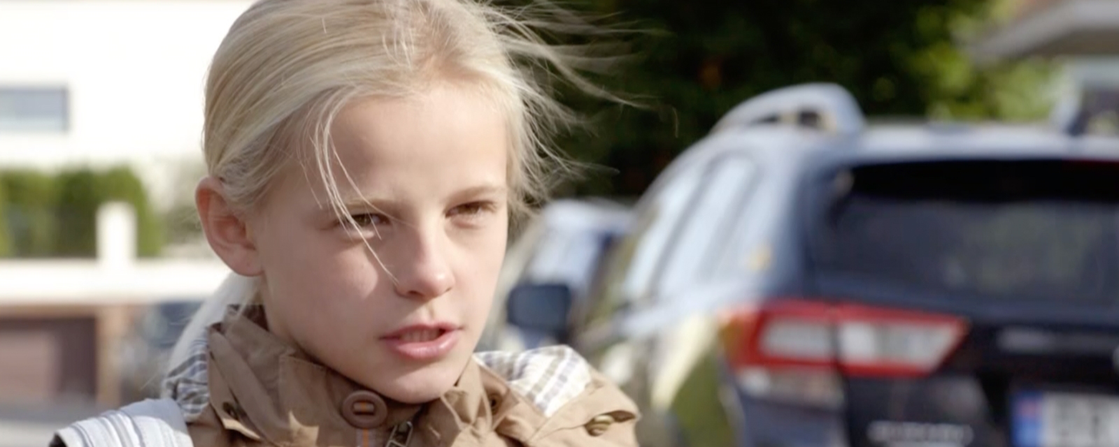 Ung jente biter tennene sammen og ser strengt mot en voksen foran seg