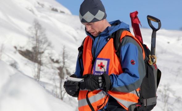 Person i hjelpekorps uniform vinter fjellside