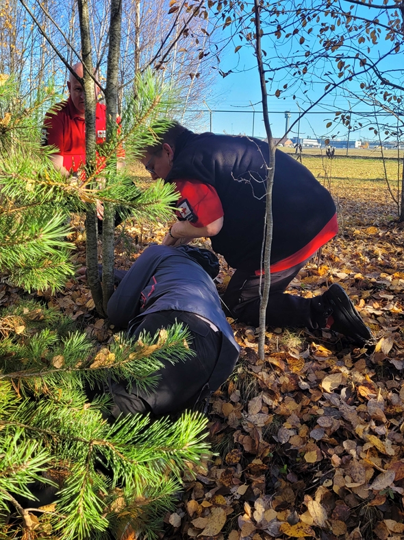 To fra hjelpekorpset utfører pasientundersøkelsen på pasient i skogen under øvelse