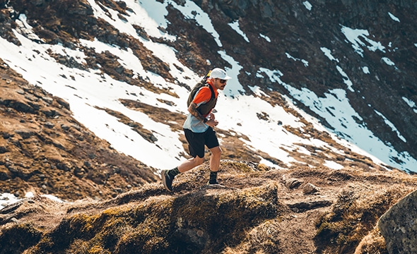 En mann løper i et snødekt landskap.