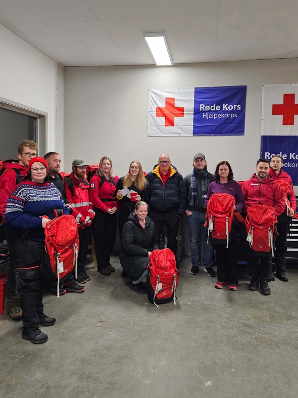 En gruppe fornøyde medlemmer i Hjelpekorpset viser frem de nye beredskapssekkene sine.