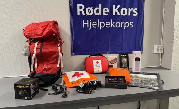 Den nye beredskapssekken er stilt ut på et bord med utstyr som følger med.