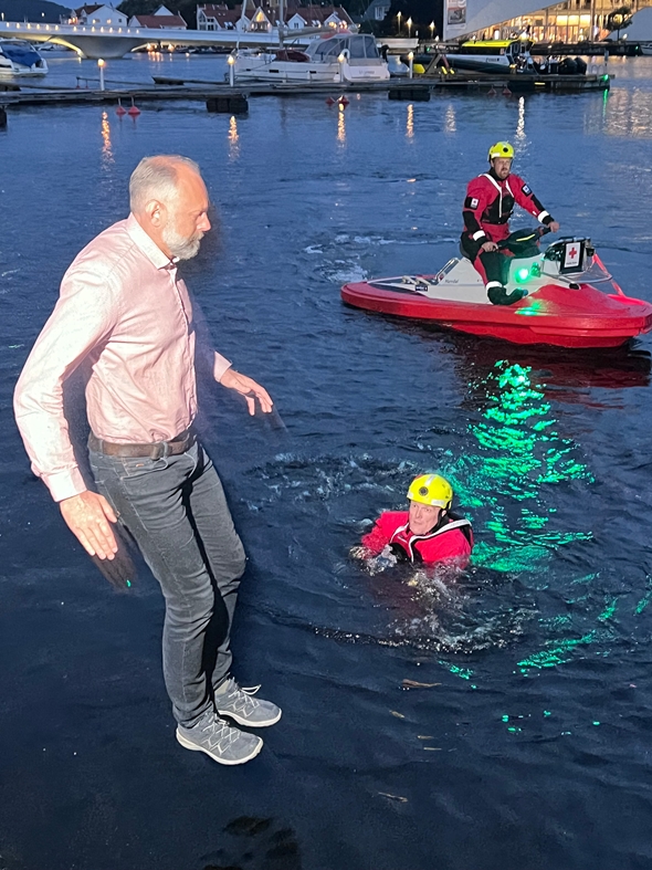 Mann hopper til vanns i mørket.