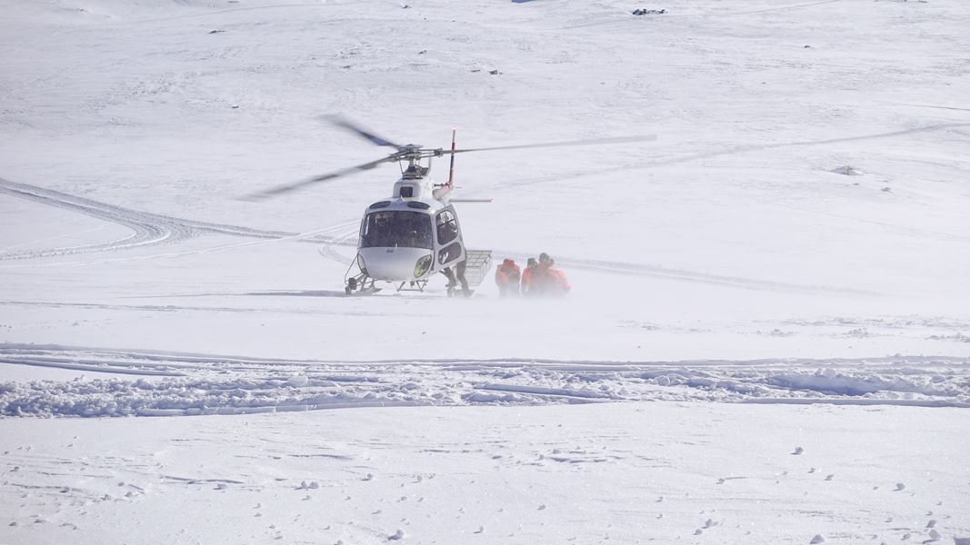 Helikopter frakter hjelpemannskap inn til et skredområde.