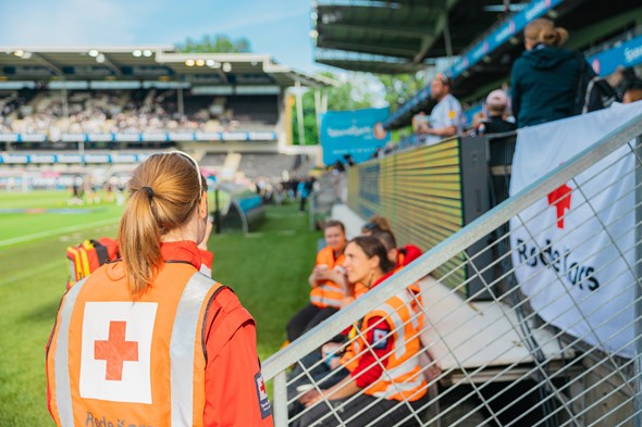 Røde Kors-frivillige på vakt ved en fotballstadion.