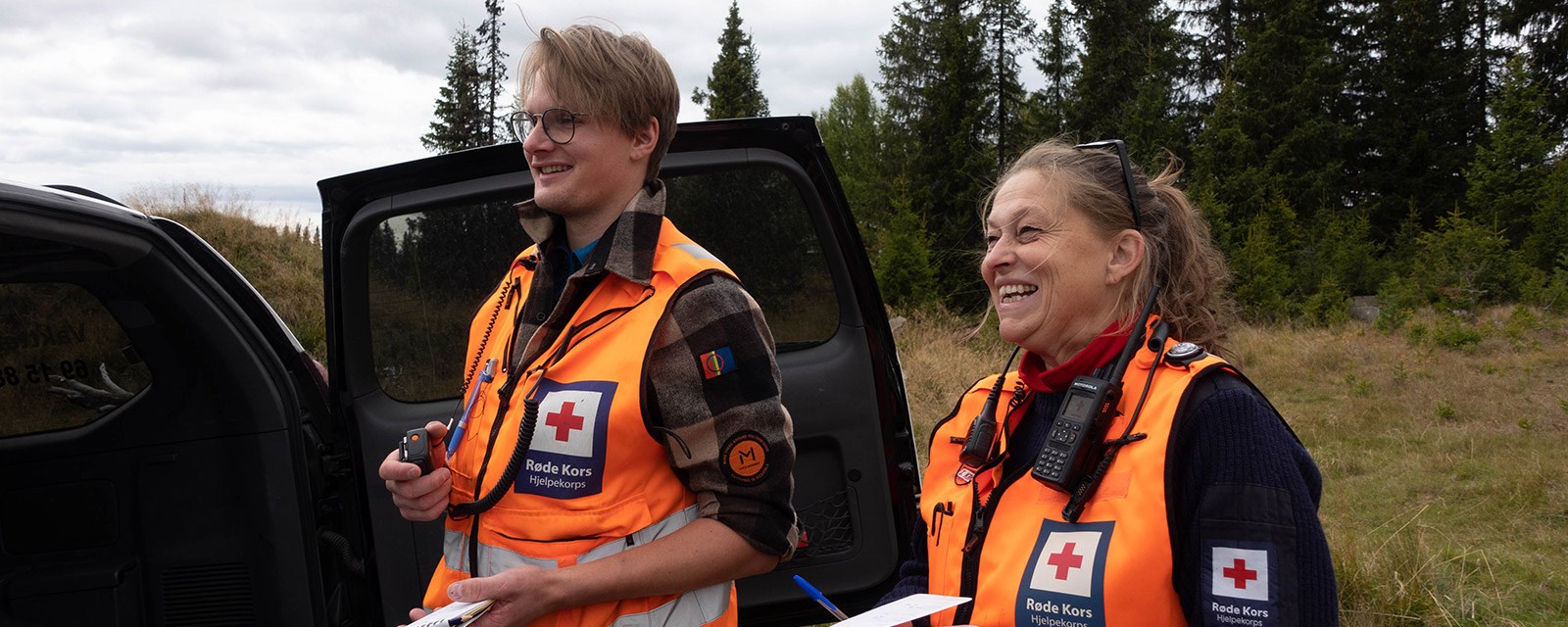 To deltakere fra Røde Kors smiler og ler.