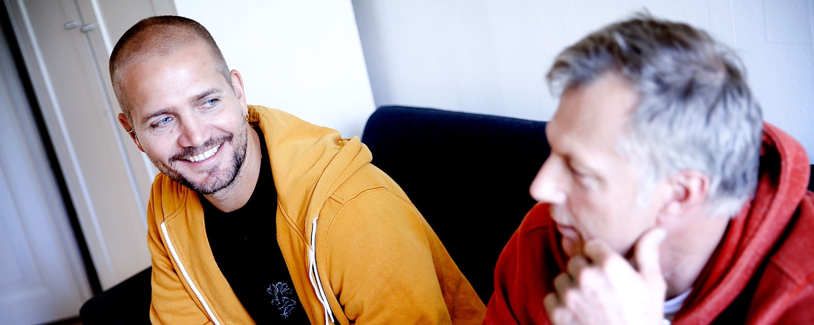 To menn i sofa, samtale.