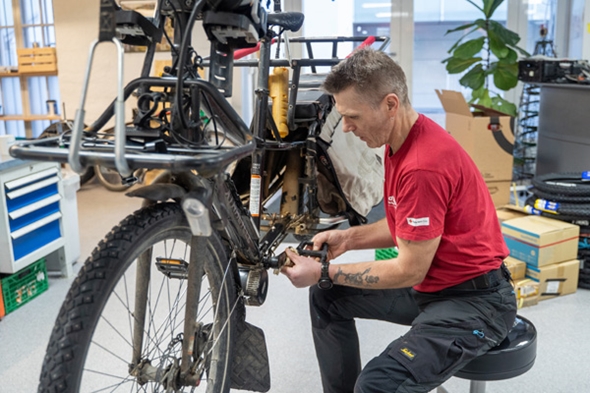 Mann som fikser sykkel