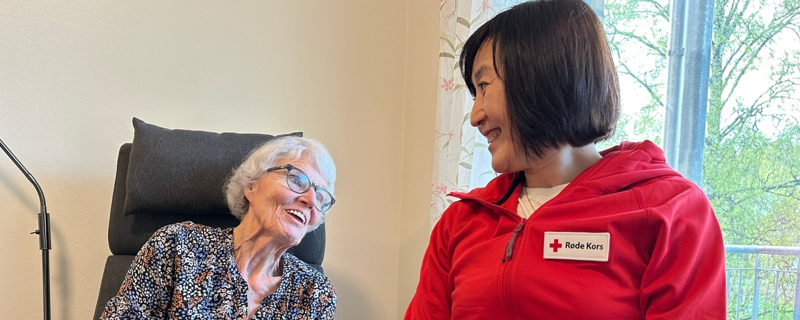 Besøksvert Anne Berit og besøksvenn Zhen ser på hverandre og smiler