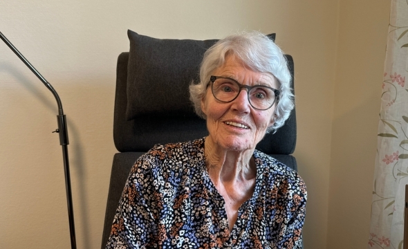 Anne Berit sitter i godstolen i stua