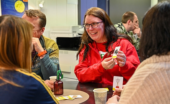 kvinne holder opp et kort for deltakere på norsktrening