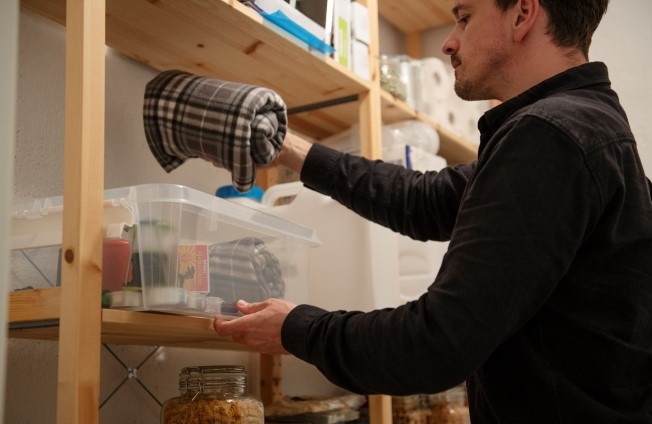 En mann tar frem en oppbevaringsboks med utstyr som  er nyttig å ha hvis en krise oppstår.