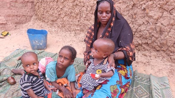 En kvinne sitter i en grop med sine 3 små barn, tørke og hundsnød