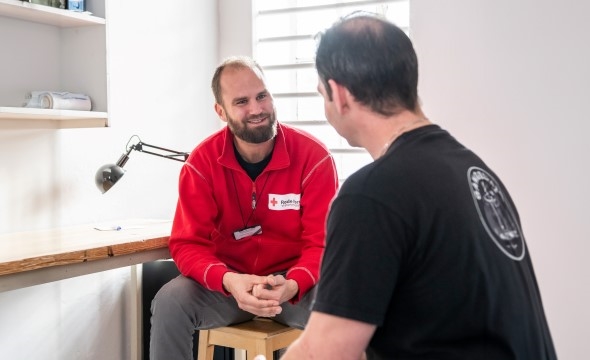 Frivillig visitor I Røde Kors snakker med en innsatt i fengsel.